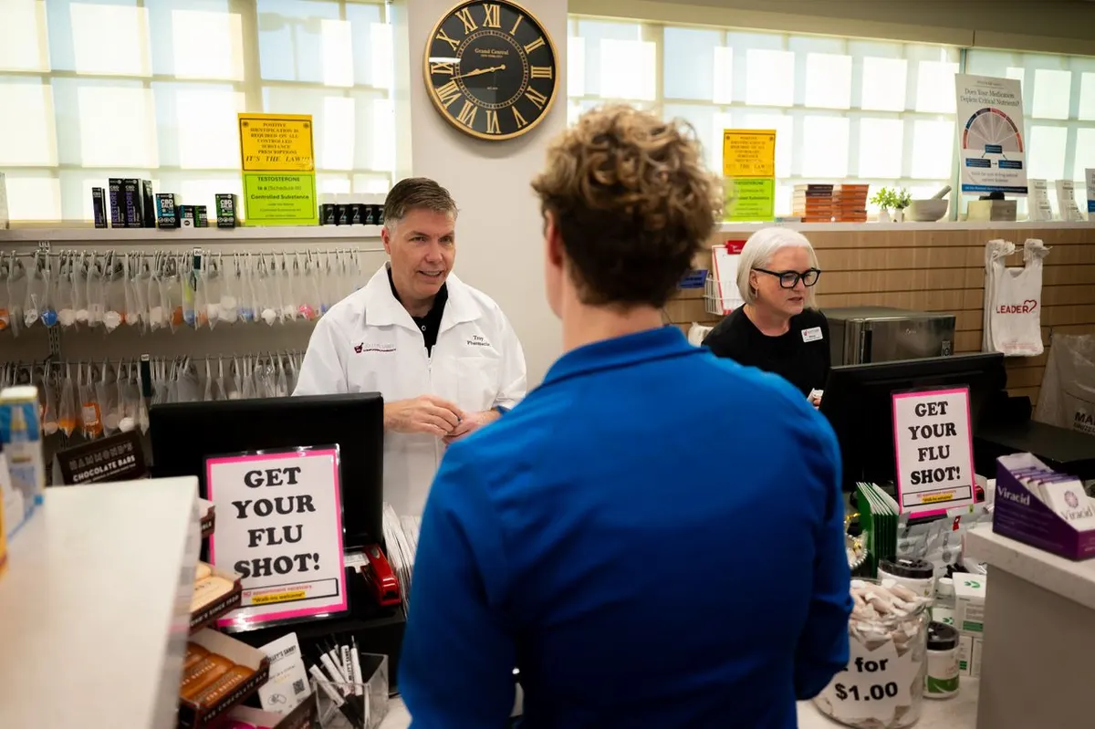 A Jolley's pharmacist speaking with a patient at the pharmacy counter about flu shots