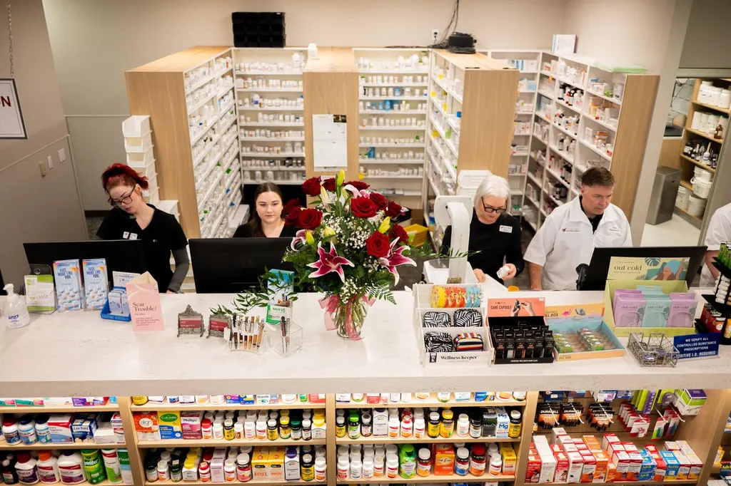 View across Jolley's pharmacy counter with staff, flowers, and stocked shelves