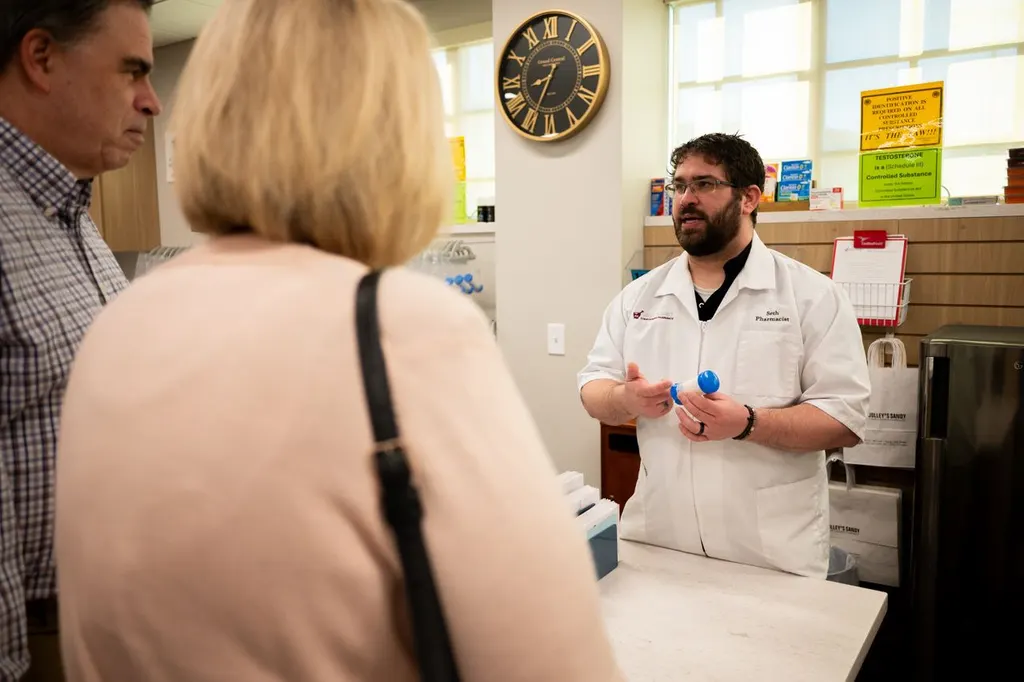 A Jolley's pharmacist speaking with two customers at the counter