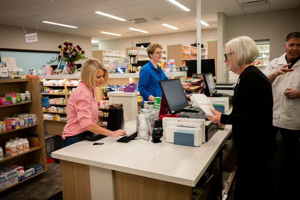 Jolley's staff assisting customers with a pharmacy bag at the pickup counter